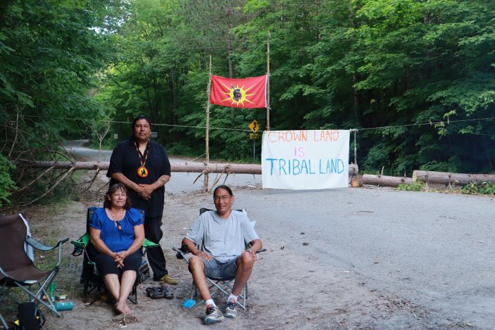 From left to right: Elizabeth Brass Elson, John Hawke (Kaikaikonas) and Earl Oegema in front of the blockade that's been set up at Awenda Provincial Park.
