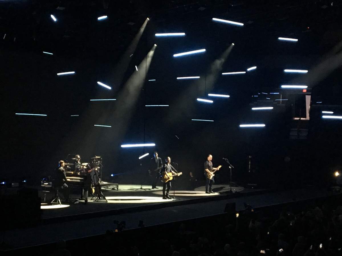 Adams and his band playing under small panels of lights attached to stings that were moving up and down throughout the show.