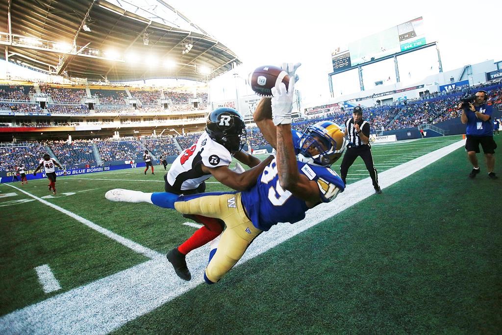 Winnipeg Blue Bombers' Kenny Lawler (89) reaches out for the catch against Ottawa Redblacks' Corey Tindal (28) during the first half of CFL action in Winnipeg, Friday, July 19, 2019.