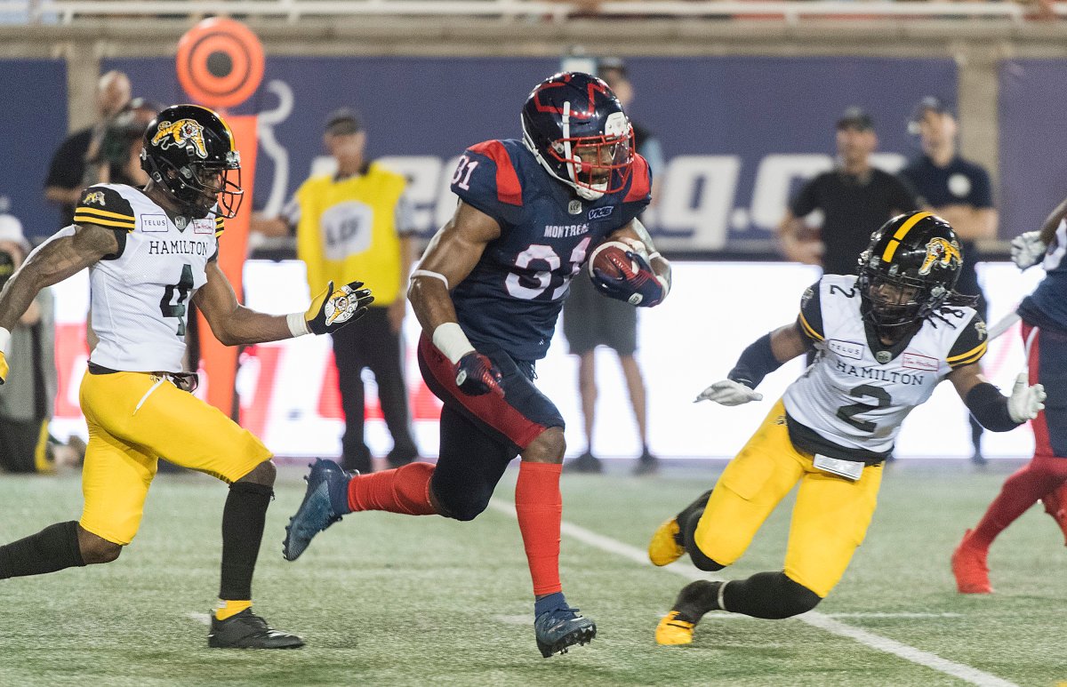 Montreal Alouettes' William Stanback (31) breaks away from Hamilton Tiger-Cats' Richard Leonard (4) and teammate Tunde Adeleke (2) during second half CFL football action in Montreal, Thursday, July 4, 2019.