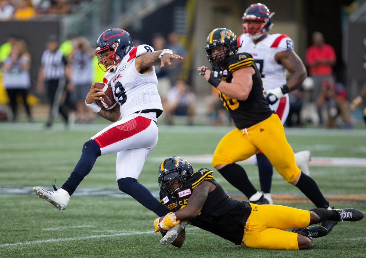 Hamilton Tiger-Cats defensive back Cariel Brooks (26) gets hold of Montreal Alouettes quarterback Vernon Adams Jr.(8) during first half CFL football game action in Hamilton, Ont. on Friday, June 28, 2019.