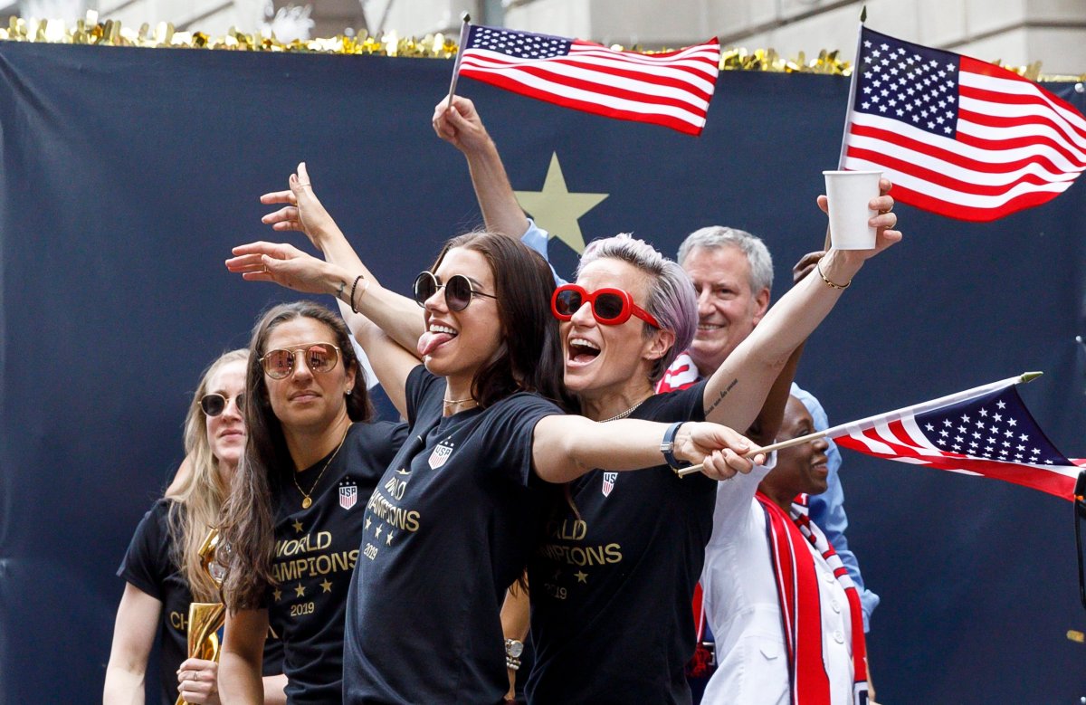 Women's soccer players Alex Morgan (L) and Megan Rapinoe (R) cheer during a ticker-tape parade celebrating the team's 2019 World Cup victory along Broadway in New York, N.Y., July 10, 2019.