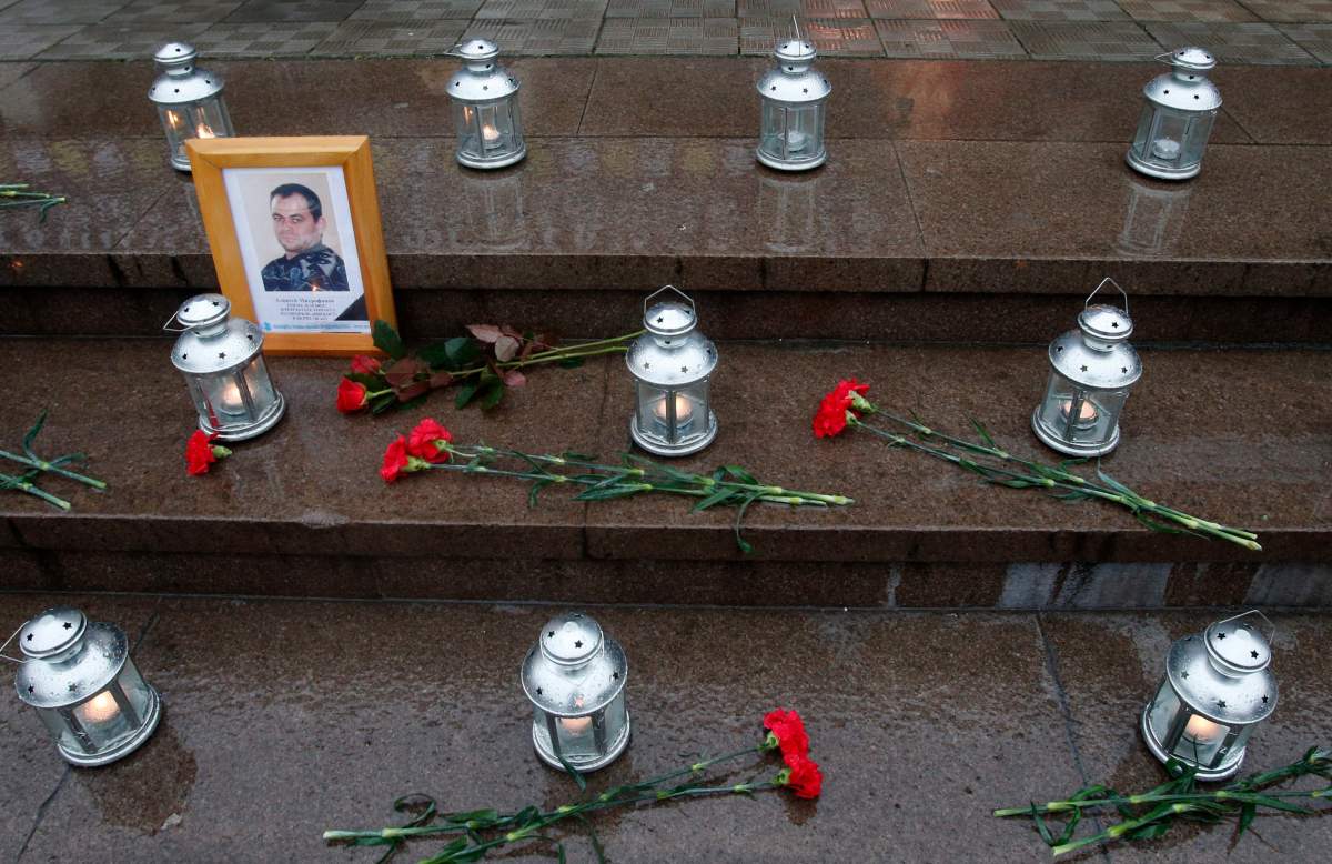 Flowers, candles and portrait of who died during terrorist attack on a Moscow theatre, lay in front of the theatre in Moscow, Russia, Friday, Oct. 26, 2012. Families the 130 people who died in a hostage crisis at a Moscow theatre 10 years ago will hold a ceremony outside the venue where Chechen militants held 912 audience members for three days.