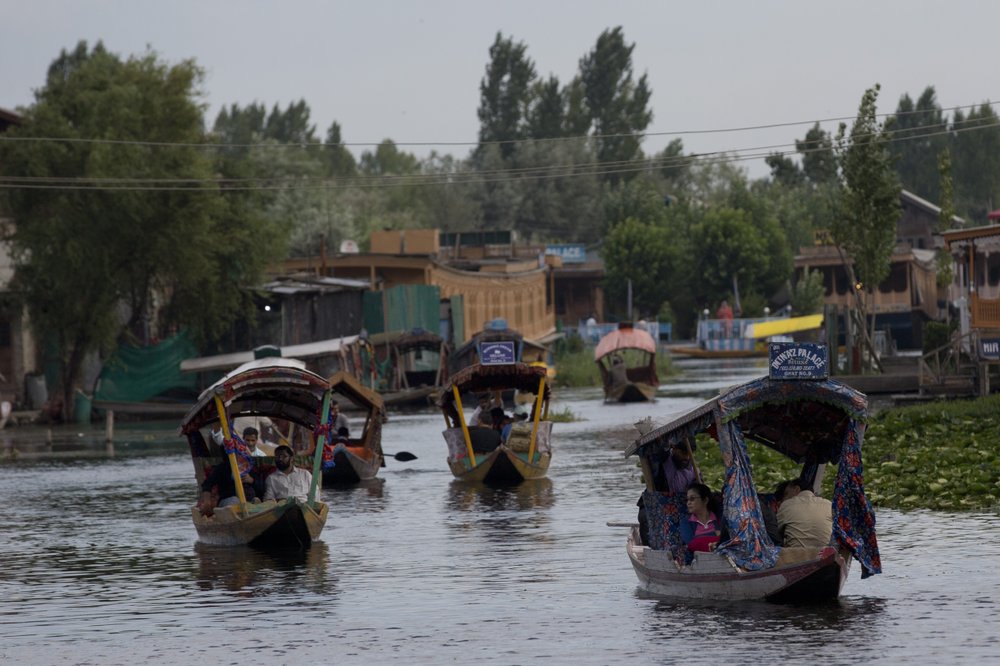 Tourists in Shikaras, a traditional gondola, cross the Dal Lake as they prepare to leave Srinagar, Indian controlled Kashmir, Saturday, Aug. 3, 2019. A government order in Indian-administered Kashmir on Friday asked tourists and Hindu pilgrims visiting a Himalayan cave shrine "to curtail their stay" in the disputed territory, citing security concerns and intensifying tensions following India's announcement it was sending more troops to the region. 