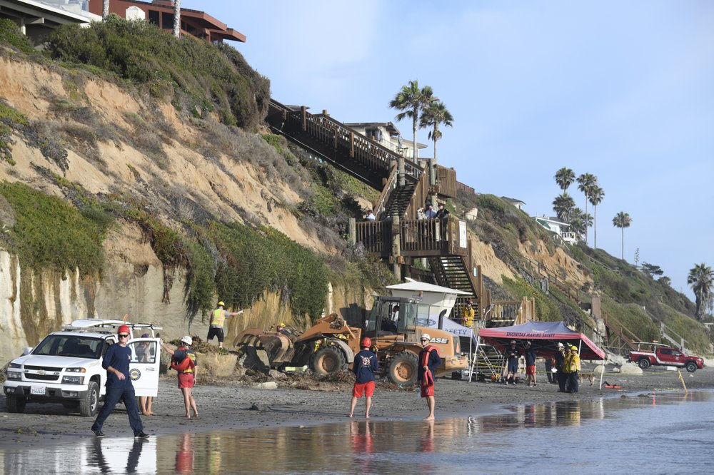Search and rescue personnel work at the site of a cliff collapse at a popular beach Friday, Aug. 2, 2019, in Encinitas, Calif. At least one person was reportedly killed, and multiple people were injured, when an oceanfront bluff collapsed Friday at Grandview Beach in the Leucadia area of Encinitas, authorities said.