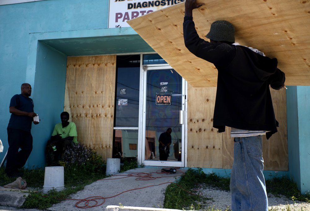 Workers board up a shop’s window front as they make preparations for the arrival of Hurricane Dorian, in Freeport, Bahamas, Friday, Aug. 30, 2019. Forecasters said the hurricane is expected to keep on strengthening and become a Category 3 later in the day. 