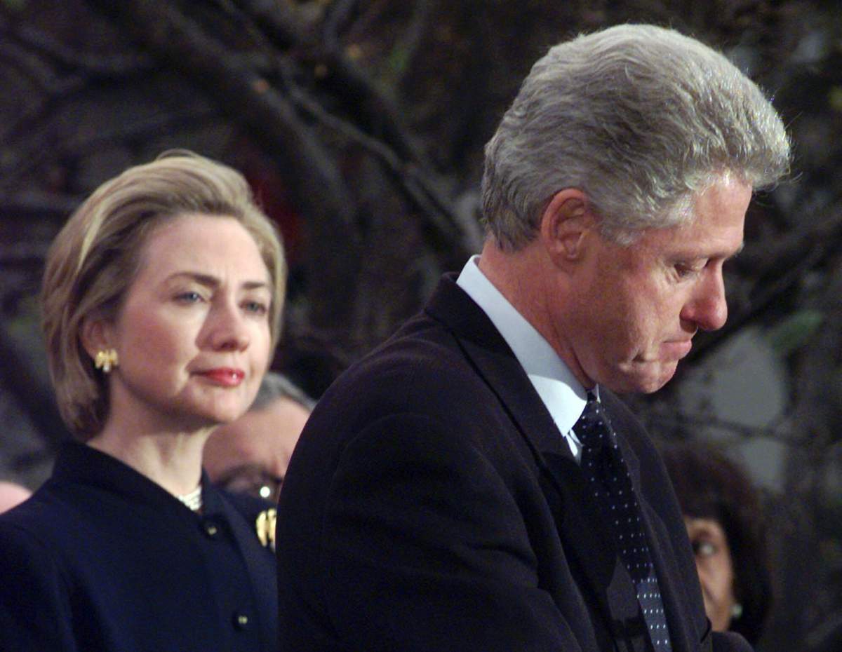 First Lady Hillary Clinton (L) watches U.S. President Bill Clinton pause as he thanks those Democratic members of the House of Representatives who voted against impeachment on Dec. 19, 1998.