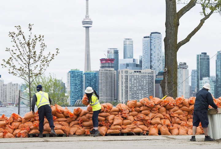 Workers stack sand bags to keep water from flooding the land more as the Toronto Islands are threatened by rising water levels in Toronto on Friday, May 19, 2017. 
