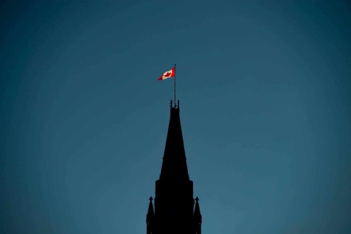 The Canadian flag is illuminated by morning light atop the Peace Tower on Parliament Hill in Ottawa on Monday, Sept. 17, 2018.