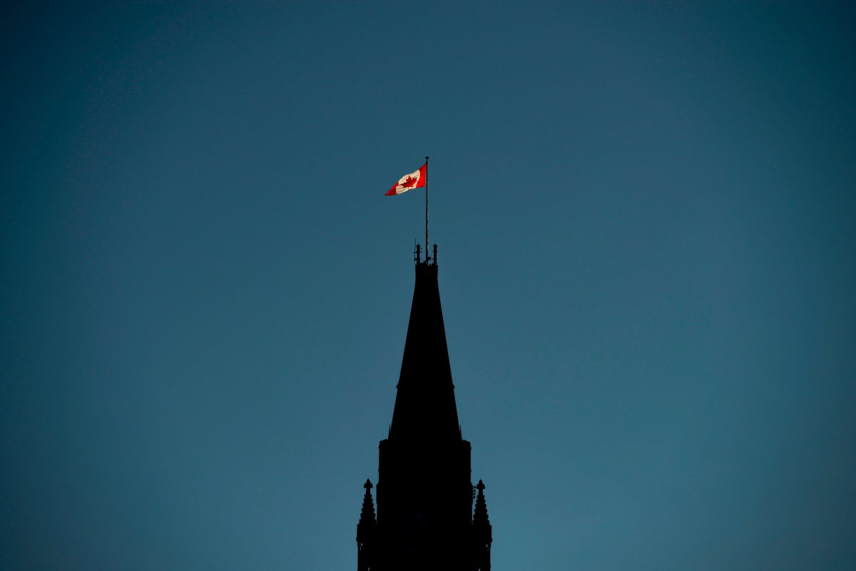The Canadian flag is illuminated by morning light atop the Peace Tower on Parliament Hill in Ottawa on Monday, Sept. 17, 2018.