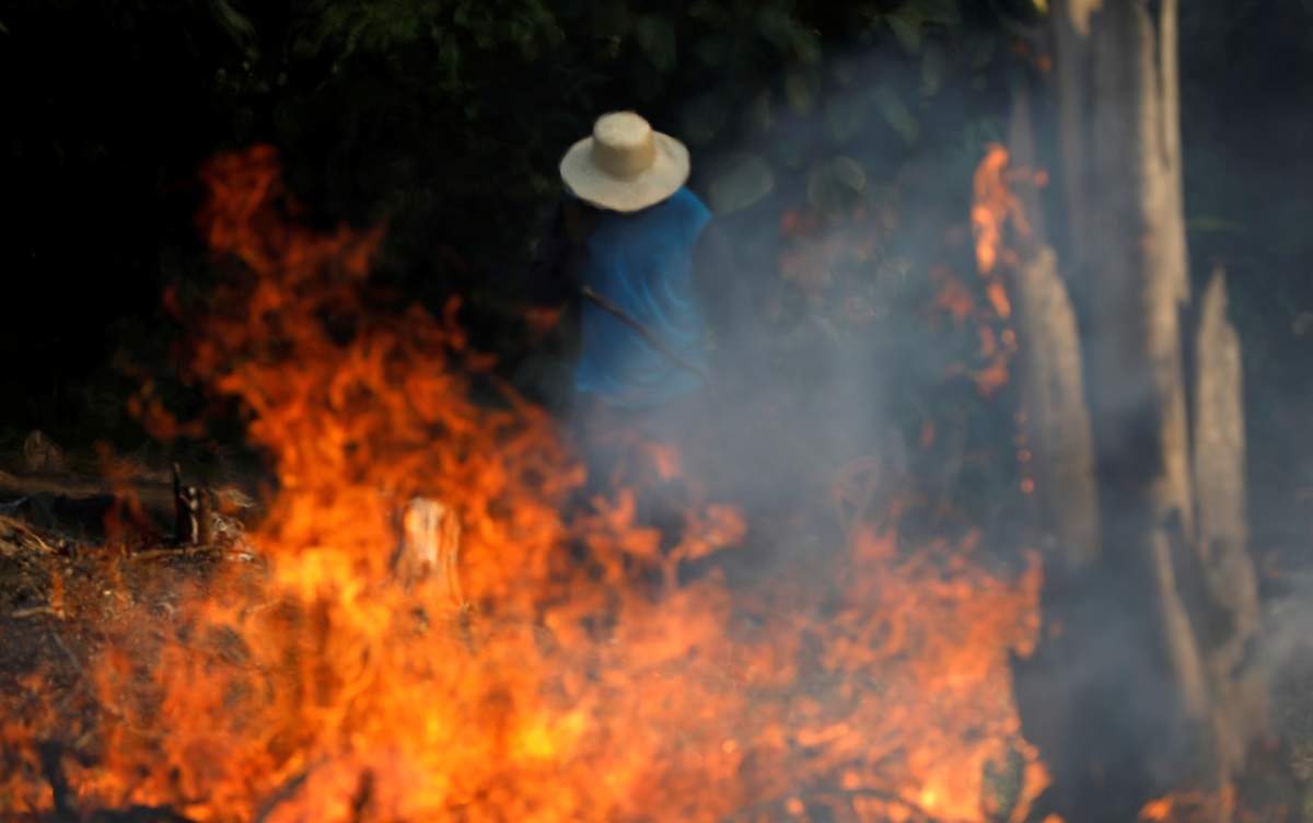 A man works in a burning tract of Amazon jungle as it is being cleared by loggers and farmers in Iranduba, Amazonas state, Brazil August 20, 2019. (REUTERS/Bruno Kelly/File Photo)