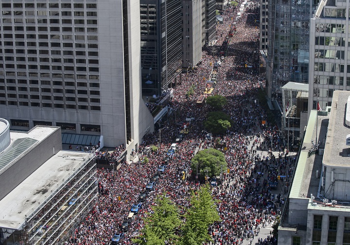 Fans cheer as the Toronto Raptors pass by during the Raptors Championship parade in Toronto on Monday, June 17, 2019. The City of Toronto is defending how police and paramedics dealt with a sick baby in the massive crowd that turned out for the Raptors NBA championship victory parade.