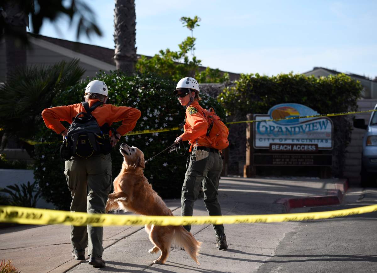 Search and rescue personnel head down to the site of a cliff collapse at a popular beach Friday, Aug. 2, 2019, in Encinitas, Calif. At least one person was reportedly killed, and multiple people were injured, when an oceanfront bluff collapsed Friday at Grandview Beach in the Leucadia area of Encinitas, authorities said.