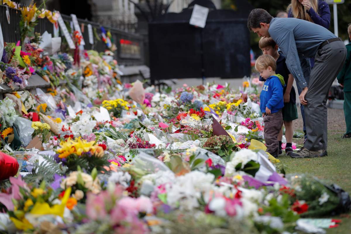 In this March 18, 2019, file photo, mourners lay flowers on a wall at the Botanical Gardens in Christchurch, New Zealand. The El Paso massacre is the latest attack in which the gunman appears to have praised the March shootings in Christchurch, where an Australian white supremacist is charged with killing 51 worshippers at two mosques. (AP Photo/Vincent Thian, File)