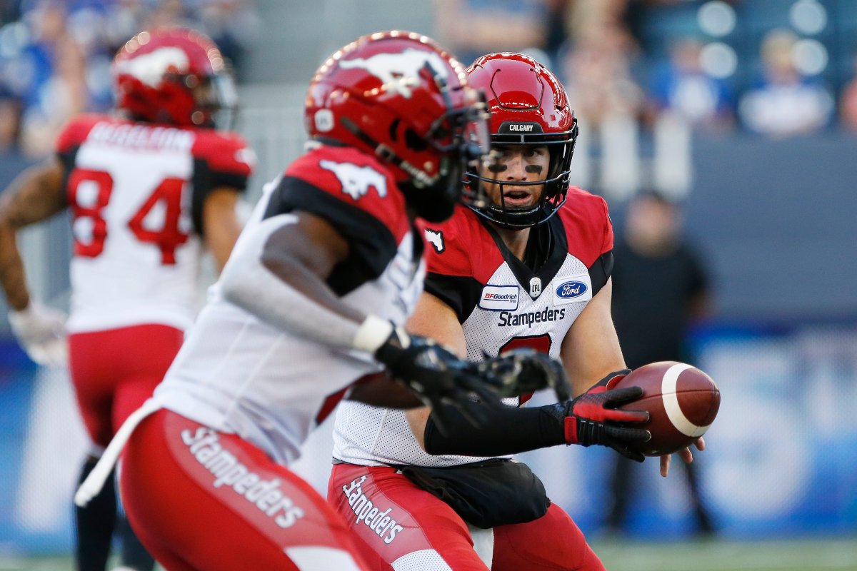 Calgary Stampeders quarterback Nick Arbuckle (9) hands off to Romar Morris (2) against the Winnipeg Blue Bombers during the first half of CFL action in Winnipeg Thursday, August 8, 2019. 