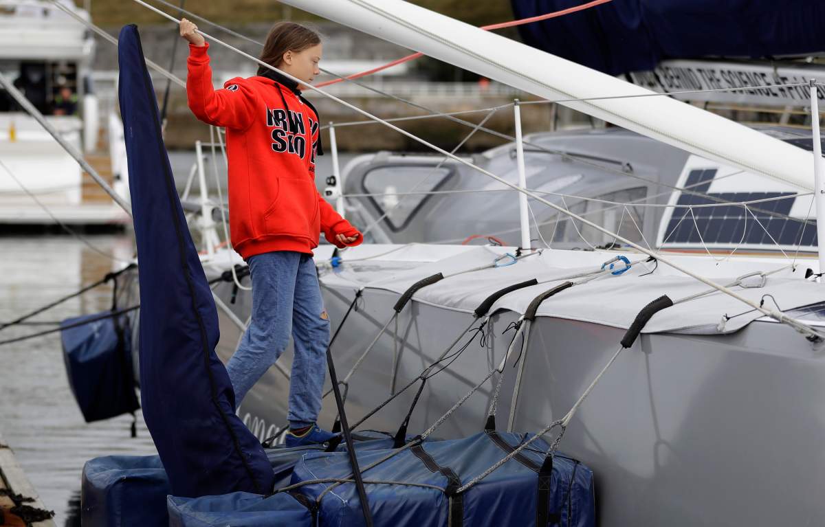 Greta Thunberg climbs onto the boat Malizia as it is moored in Plymouth, England Tuesday, Aug. 13, 2019. Greta Thunberg, the 16-year-old climate change activist who has inspired student protests around the world, is heading to the United States this week – in a sailboat. (AP Photo/Kirsty Wigglesworth)