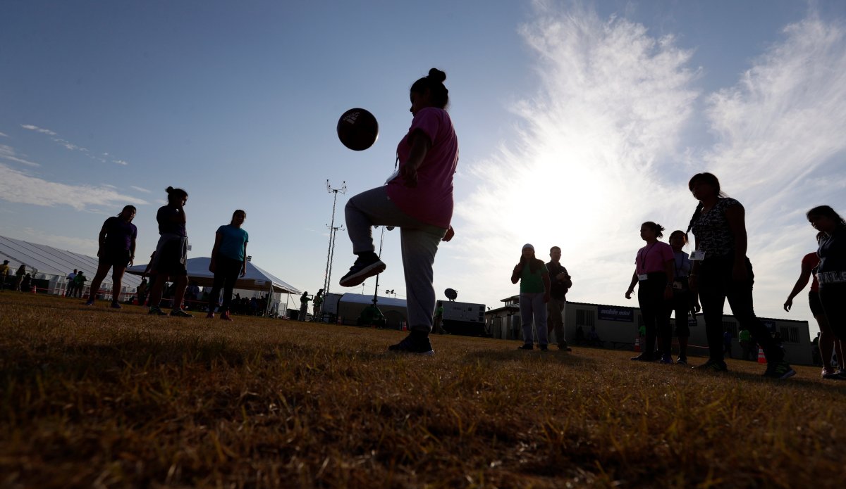 File - In this July 9, 2019, file photo, immigrants play soccer at the U.S. government's newest holding center for migrant children in Carrizo Springs, Texas.
