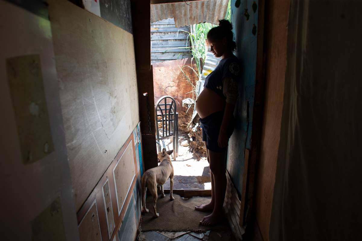In this photo taken Aug. 5, 2019, 14-year-old Rosibeth Vargas, who is seven months pregnant, stands inside her home where she lives with her parents, 18-year-old sister and nephew, in the Tablitas area of the Caucaguita neighborhood on the outskirts of Caracas, Venezuela. 