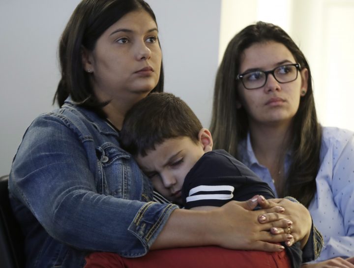 Sirlen Costa, of Brazil, holds her son Samuel, 5, as her niece Danyelle Sales, right, looks on during a news conference, Monday, Aug. 26, 2019, in Boston. Costa brought her son to the United States seeking treatment for his short bowel syndrome. Doctors and immigrant advocates say federal immigration authorities are unfairly ordering foreign born children granted deferred action for medical treatment to return to their countries. 