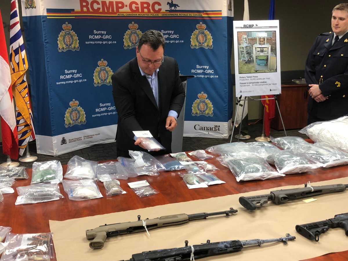 Head investigators from Surrey RCMP and federal law enforcement show off several packages of drugs and firearms seized during a search warrant execution at a South Surrey home on Aug. 6, 2019.