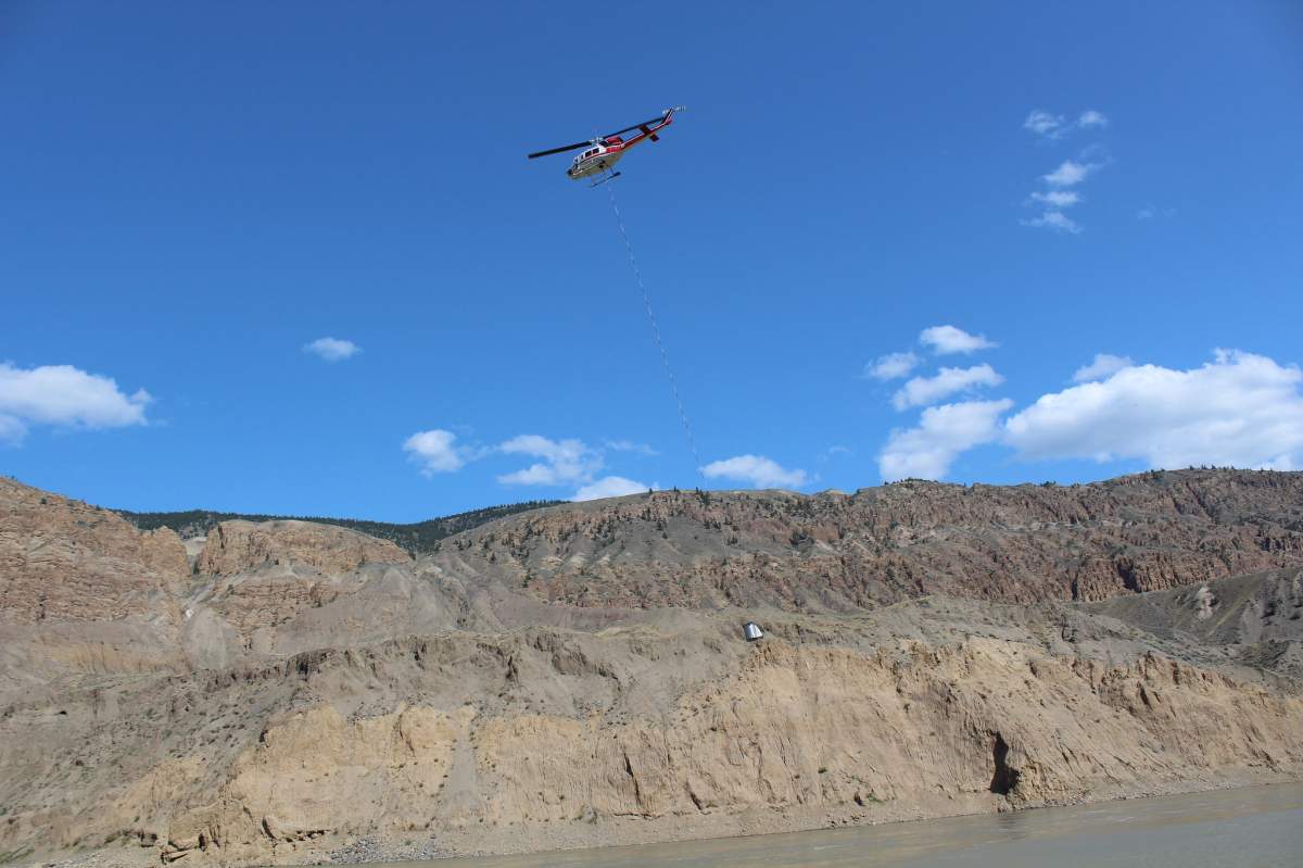A helicopter moves a transport tank filled with salmon upstream of the landslide in the Fraser River near Big Bar, B.C. on Aug. 12, 2019.