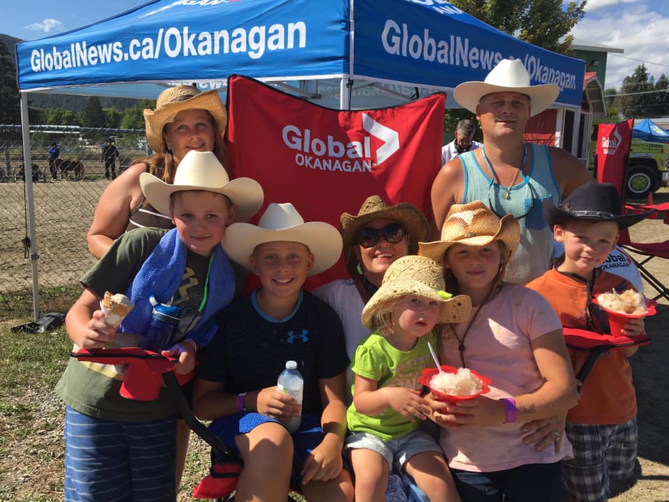 A family takes in the Global News #bigredchair at the Interior Provincial Exhibition in Armstrong on Wednesday. 