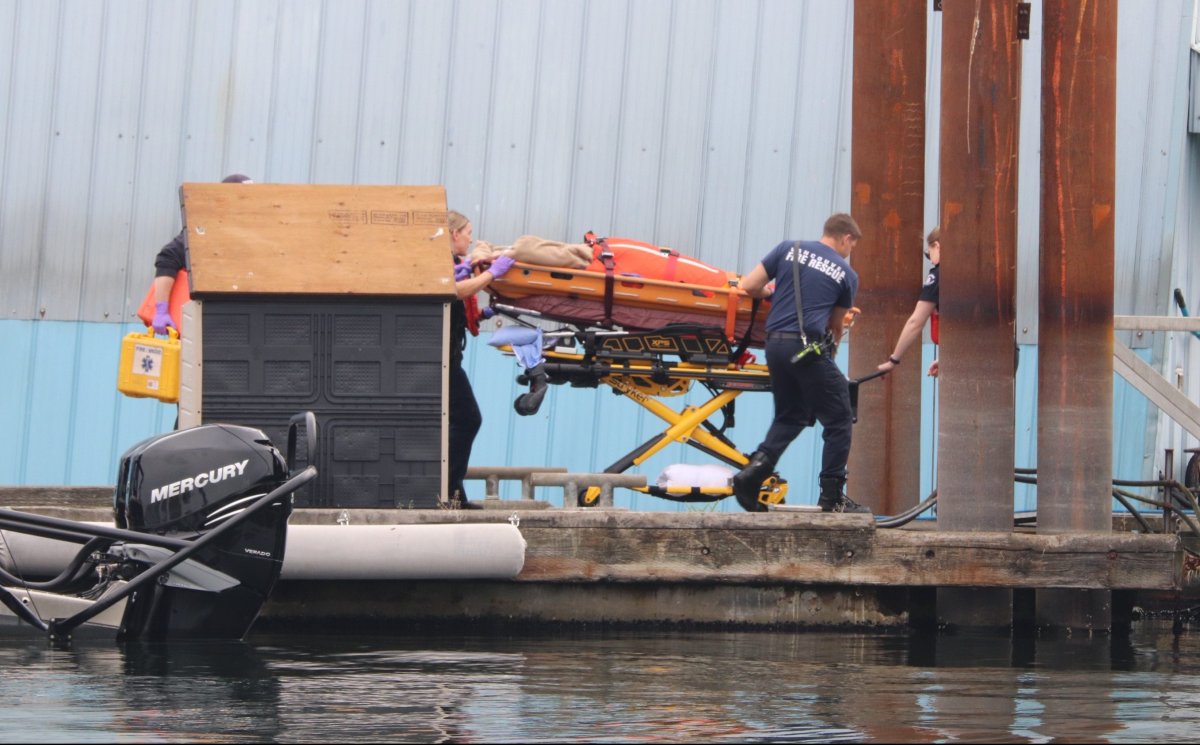 Paramedics use a stretcher to transport a woman who was seriously injured in a boat crash at the north end of Indian Arm, B.C., on Aug. 23, 2019.