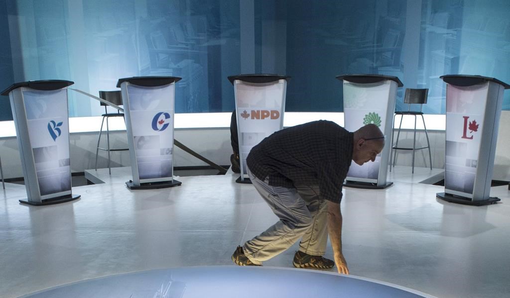 A technician cleans the set in preparation for a leaders debate, Wednesday, September 23, 2015 in Montreal. Leaders of five major parties have received invitations to participate in federal leaders' debates in October, with the People's Party of Canada left out for now.THE CANADIAN PRESS/Paul Chiasson.