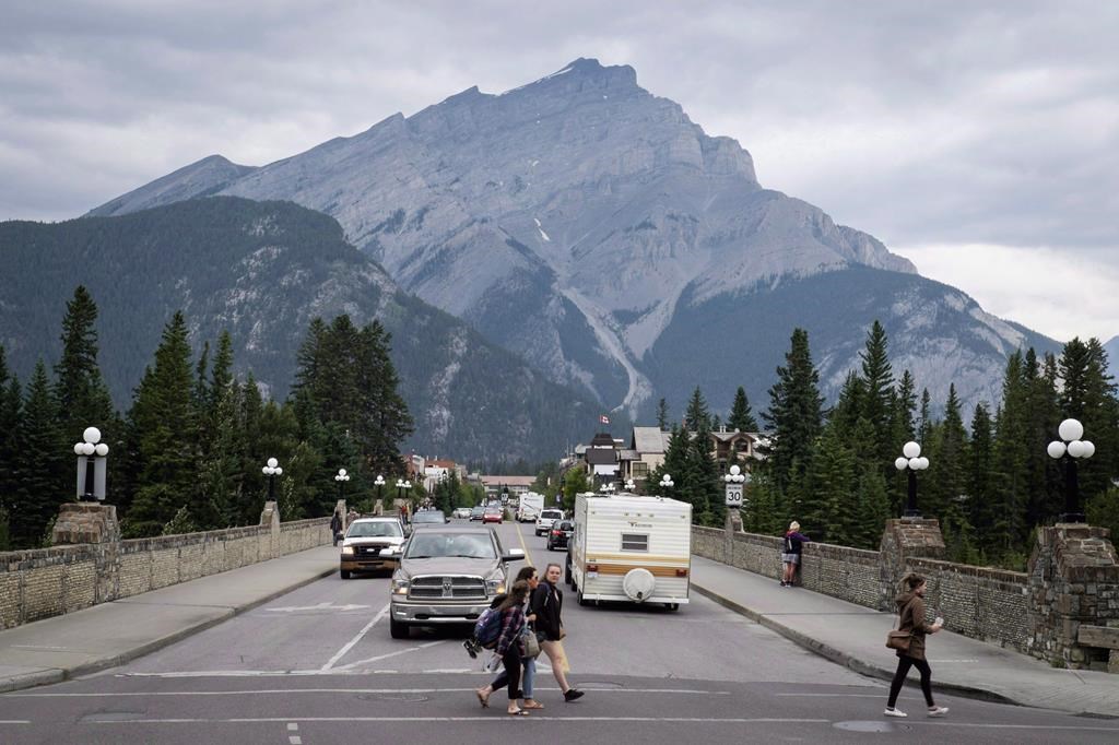 Pedestrians cross the street in Banff, Alta., in Banff National Park on July 21, 2017.