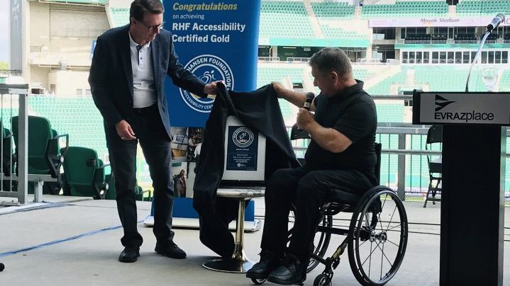 Mayor Michael Fougere and Rick Hansen unveil Mosaic Stadiums gold rating award for its accessibility measures.