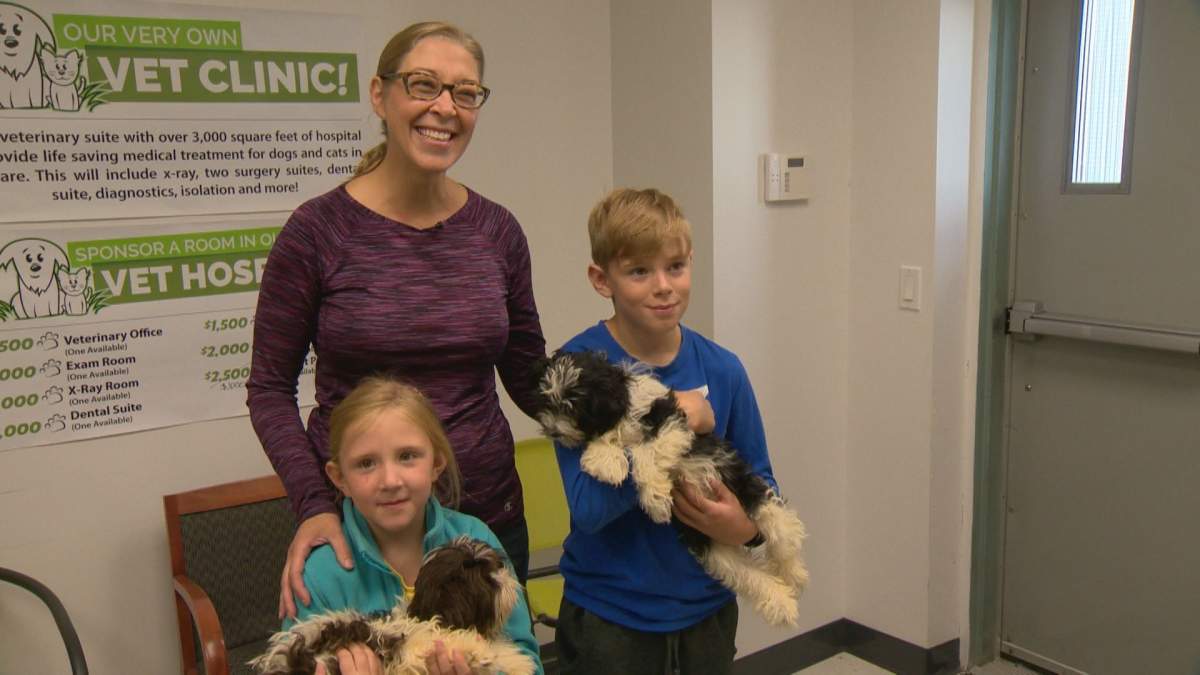 Karen Taylor and her children pose with foster puppies Cotton and Flopsy.