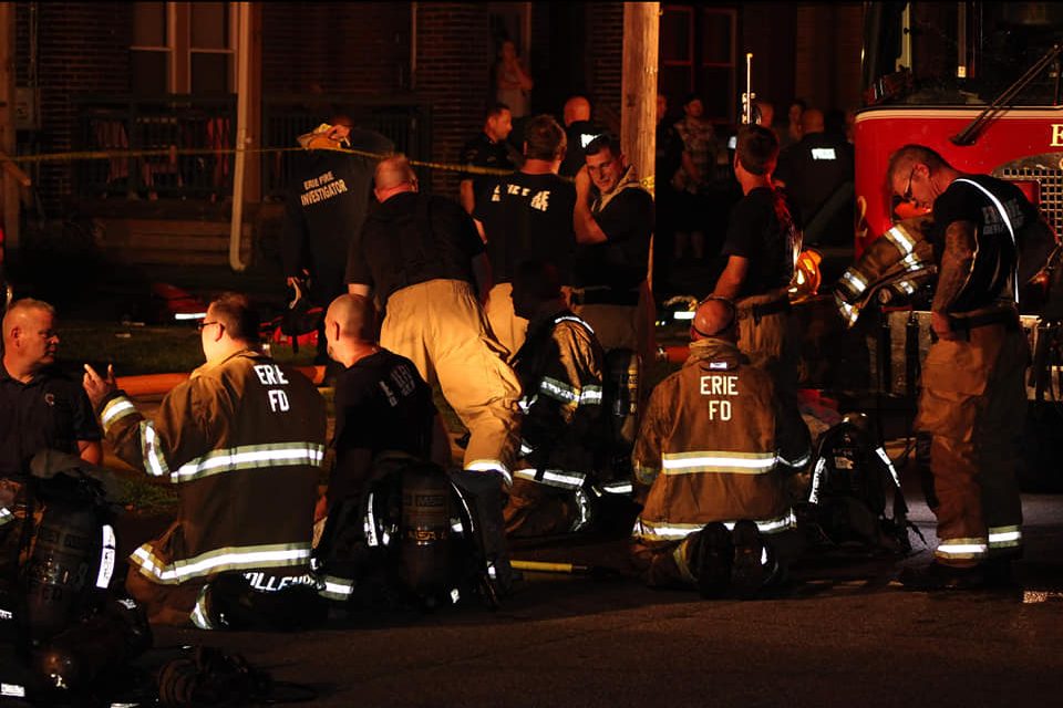Firefighters in Erie, Penn., kneel in grief outside a home daycare where five children died in a blaze on Aug. 11, 2019.