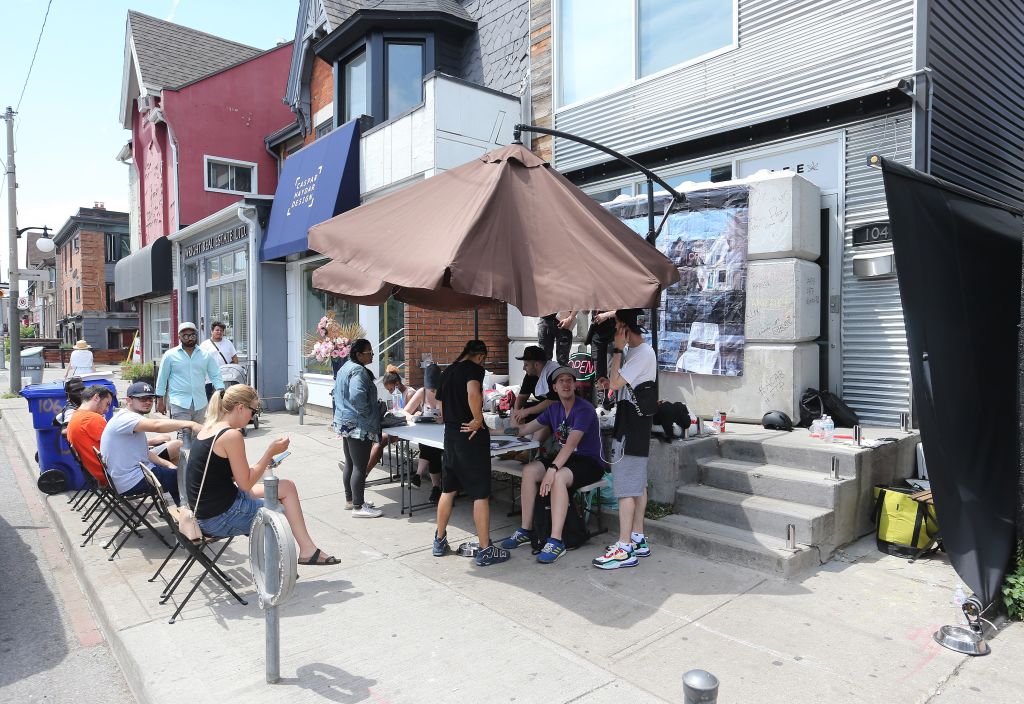 Tables and chairs and people with iPads line the sidewalk after local officials replaced the blocks in front of a grey-market dispensary at 104 Harbord St. in Toronto. 