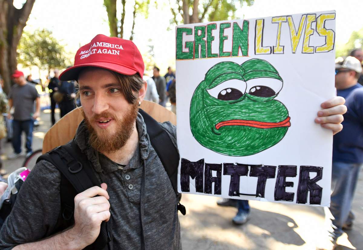 Andrew Knight holds a sign of Pepe the Frog, a conservative icon, during a rally in Berkeley, California on April 27, 2017. (JOSH EDELSON/AFP/Getty Images)