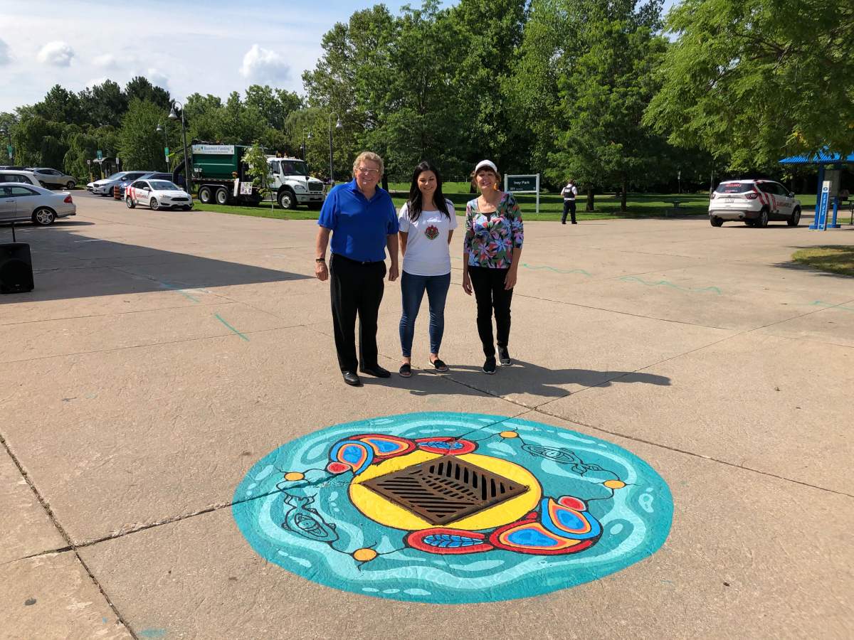 Holly Pichette, middle, poses alongside London Mayor Ed Holder and Ward 9 Coun. Anna Hopkins in front of her artwork in Ivey Park.