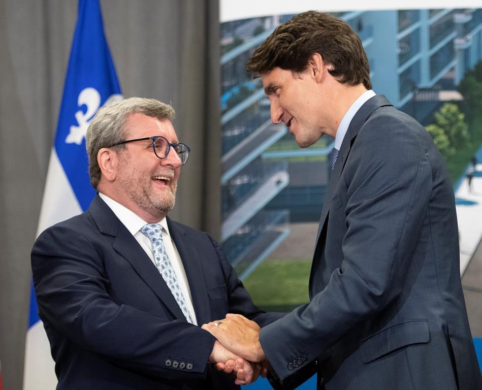 Prime Minister Justin Trudeau, right, shakes hand with Quebec City mayor Regis Labeaume after they announced a major investment for a tramway, Monday, August 19, 2019 in Quebec City.