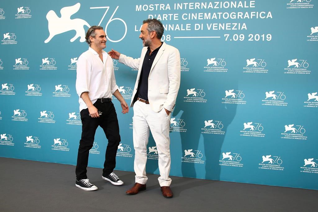 Actor Joaquin Phoenix, left, greets director Todd Phillips at the photo call for the film ‘Joker’ at the 76th edition of the Venice Film Festival in Venice, Italy, Saturday, Aug. 31, 2019. (Photo by Joel C Ryan/Invision/AP)