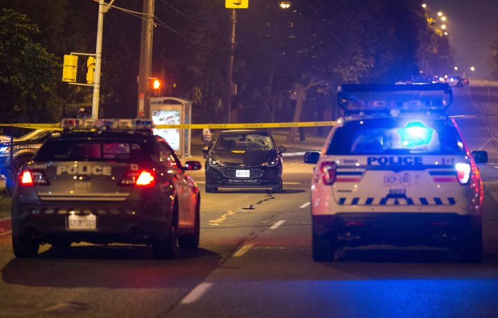 A dark-coloured sedan with a smashed windshield was at the scene of the collision.