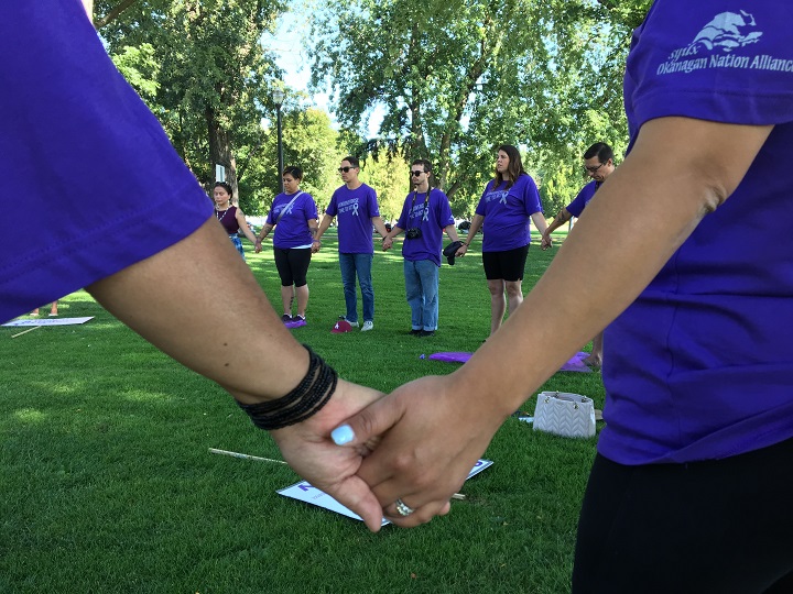 Members of the Purple Ribbon Campaign Caravan hold hands while gathering in City Park in Kelowna on Wednesday morning. The goal of two-day campaign is to raise awareness, educate people about addiction.  .
