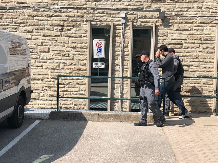 Raja Dosanjh is led away from Guelph's Superior Court of Justice by police officers after being convicted of first-degree murder on Thursday afternoon.