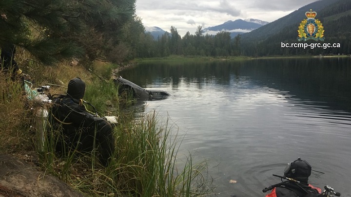 Members of the RCMP’s Underwater Recovery Team look on as a subermged vehicle is towed out of Griffin Lake on Aug. 24.
