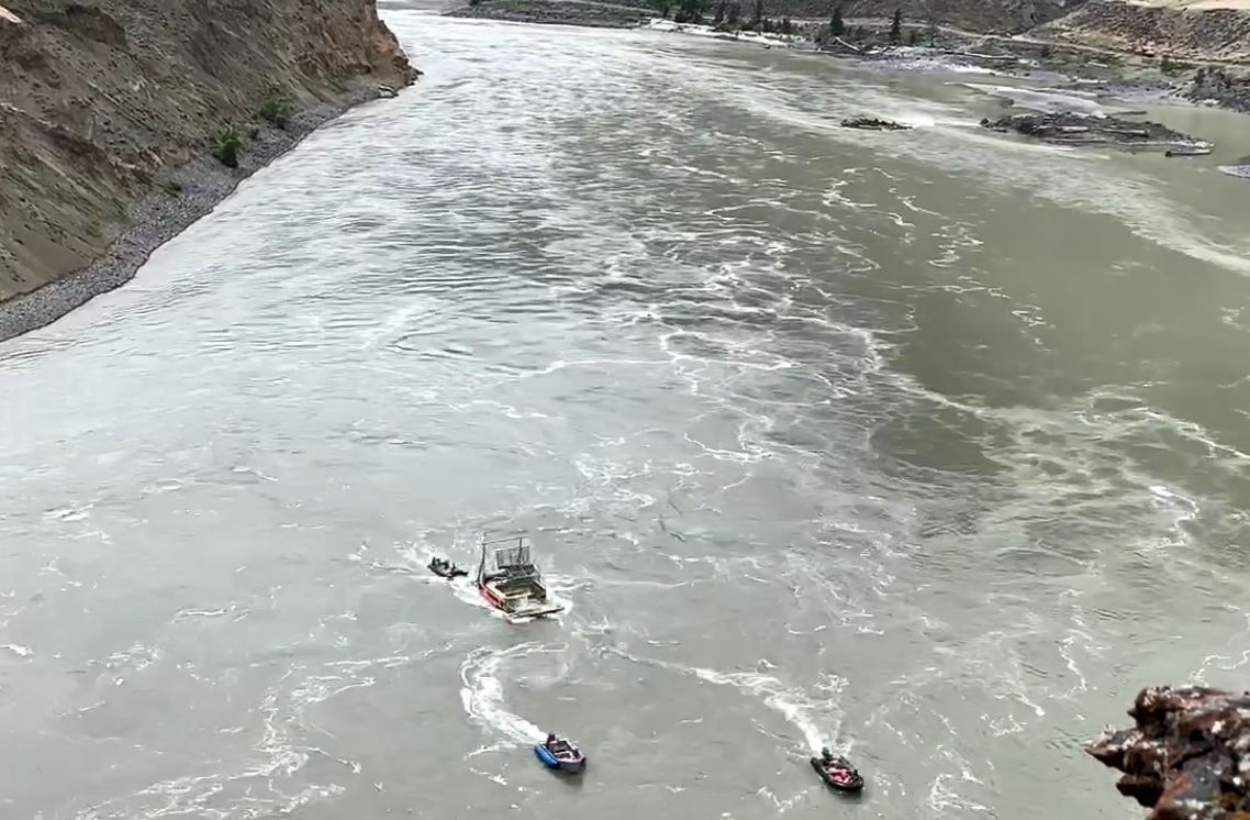 Boats tow a fish wheel into place near the Big Bar landslide in the Fraser River on Aug. 2, 2019.