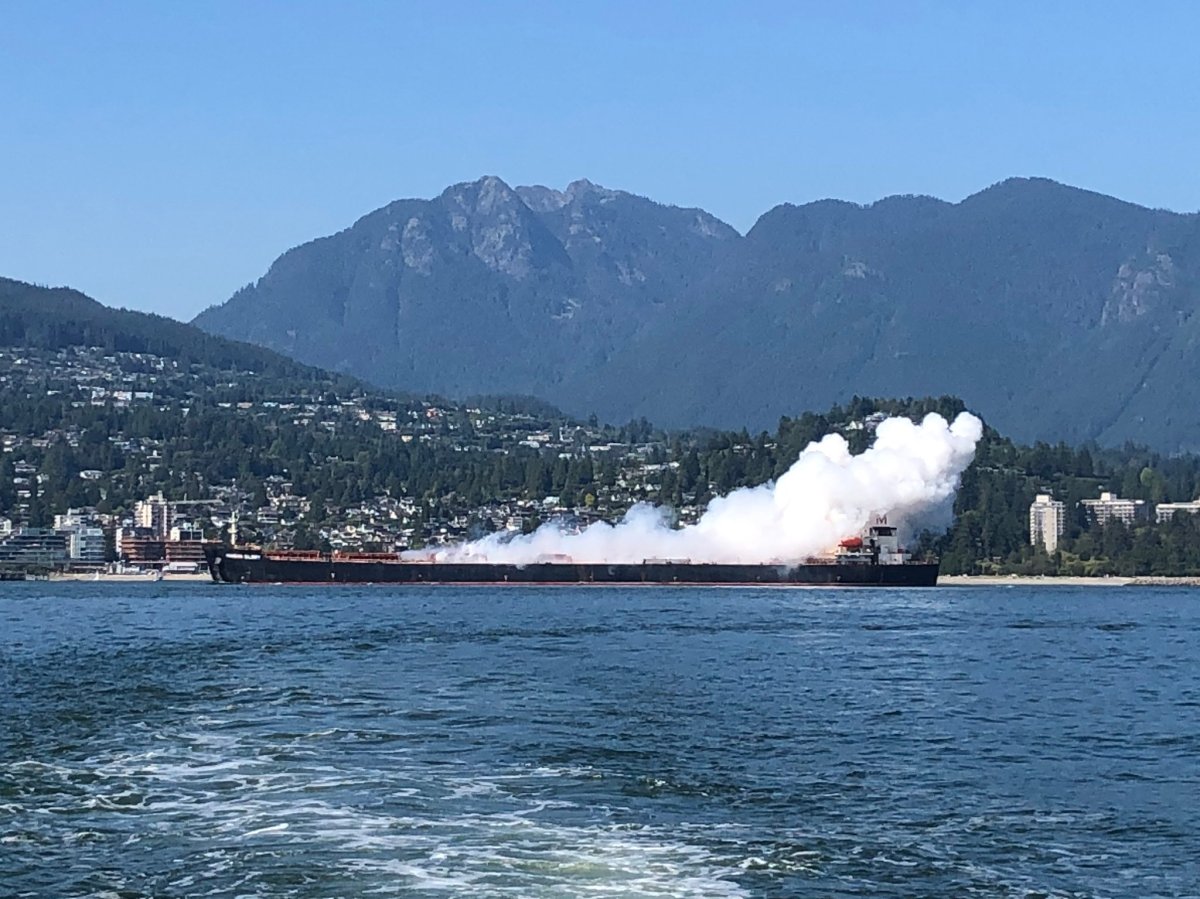 Plumes of steam or gas were pouring off a cargo ship near the Lions Gate Bridge.