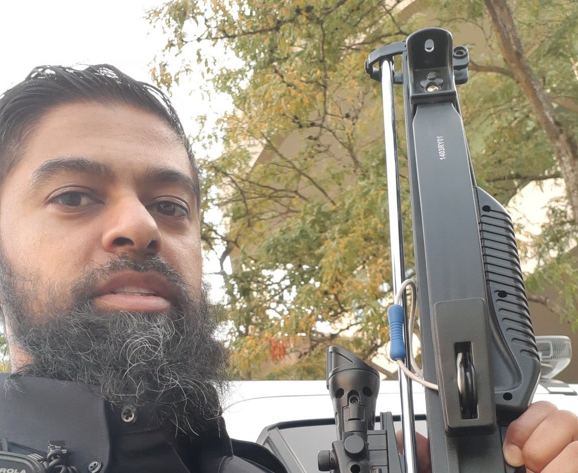 Const. Shiraaz Hanif poses with a toy crossbow he confiscated from a SkyTrain rider in Burnaby on Aug. 3, 2019.