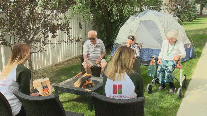 Preston Park II Retirement home residents and staff sit around a camp fire.
