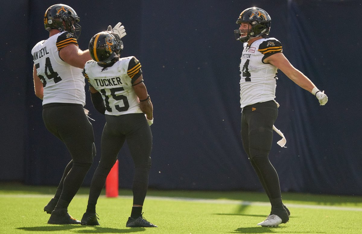 Nikola Kalinic (R) celebrates his touchdown with Chris Van Zeyl (L) and Marcus Tucker during third quarter CFL action between the Ticats and the Toronto Argonauts in Toronto on Saturday June 22, 2019.