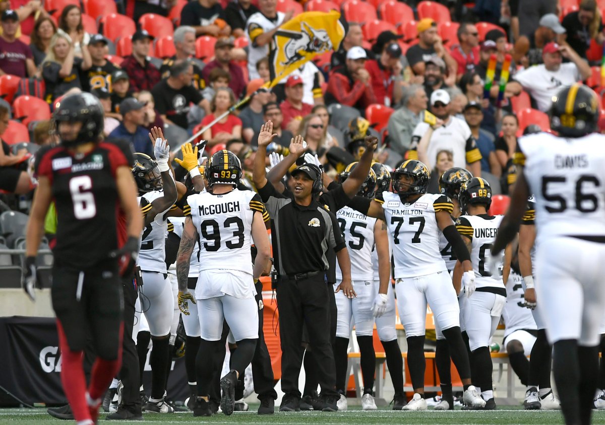 Hamilton Tiger-Cats head coach Orlondo Steinauer high-fives his players during the final moments of second half CFL football action against the Ottawa Redblacks in Ottawa on Saturday, Aug. 17, 2019.