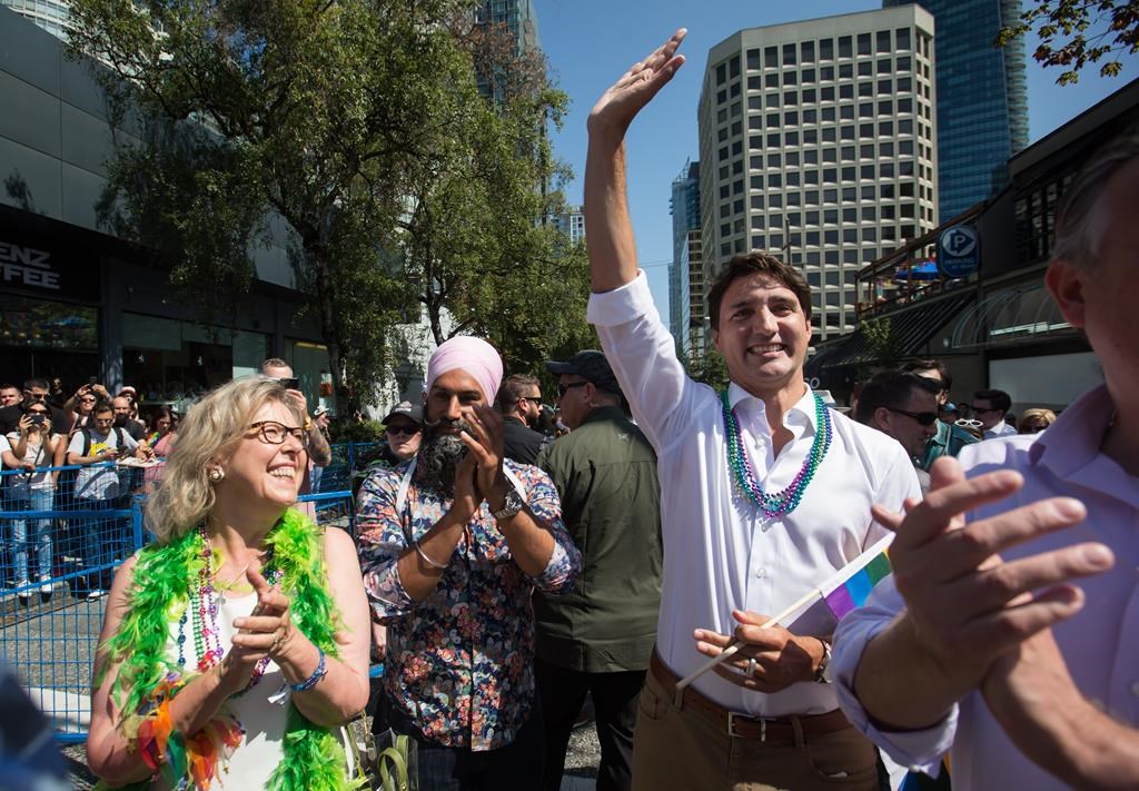 Prime Minister Justin Trudeau, right, waves to the crowd while waiting to march in the Vancouver Pride Parade with Green Party Leader Elizabeth May, left, and NDP Leader Jagmeet Singh, centre, in Vancouver, on Sunday August 4, 2019.