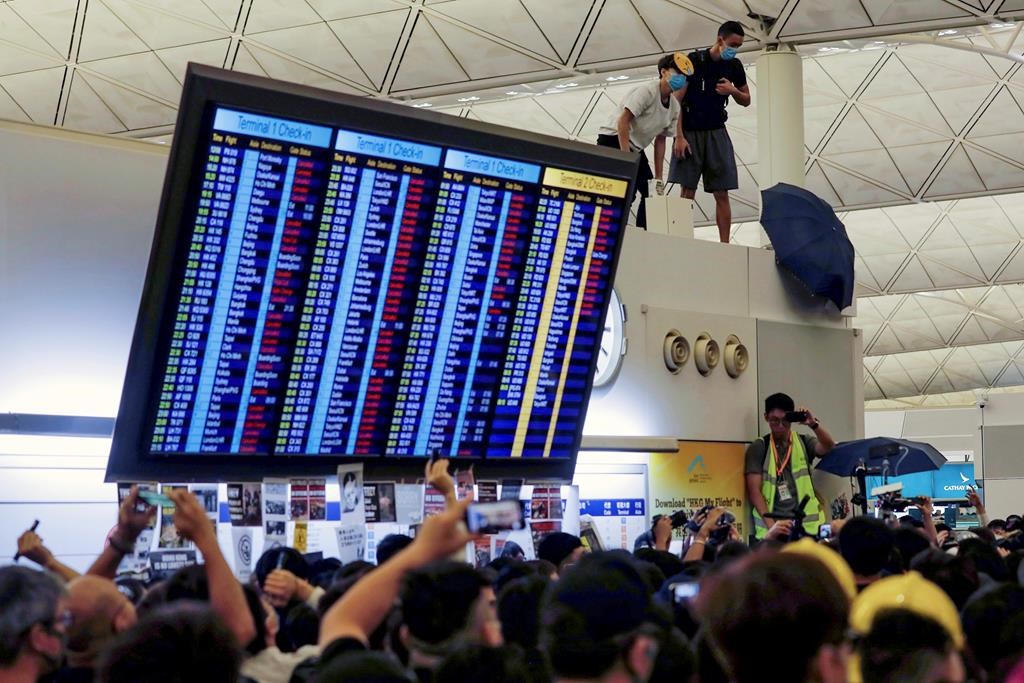 Protester use umbrellas to block surveillance cameras during a demonstration at the Airport in Hong Kong, Tuesday, Aug. 13, 2019. THE CANADIAN PRESS/AP-Vincent Yu