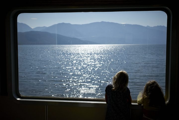 Passengers look at the view framed by a window on the Kootenay Bay to Balfour, B.C., ferry Saturday, Aug. 6, 2011. The BC Ferries run is the longest free ferry in North America.